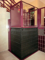 Plataforma salvaescaleras vertical modelo izaro de color rojo instalada en una comunidad de vecinos de Xtiva (Valencia).