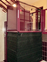 Plataforma salvaescaleras vertical modelo izaro de color rojo instalada en una comunidad de vecinos de Xtiva (Valencia).